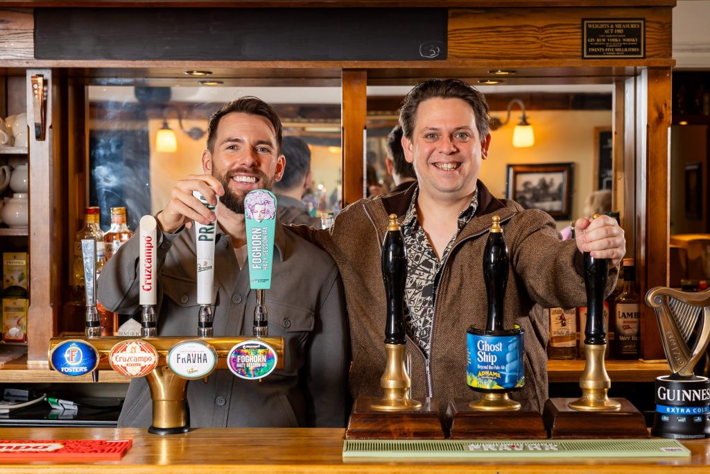 Oliver and James Claxon standing proudly behind the bar at The New Inn