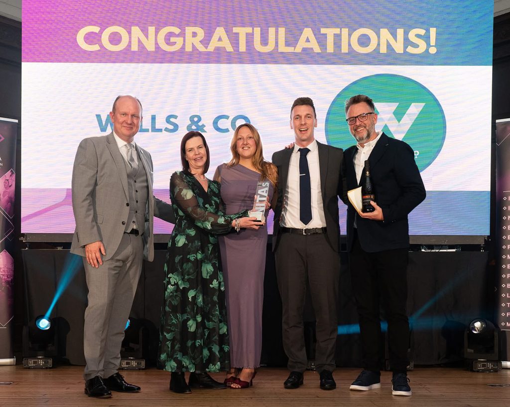 Ros Cummings, Isabelle Squire and Jacob Prichard accepting the award at the NITAs on behalf of Wells & Co